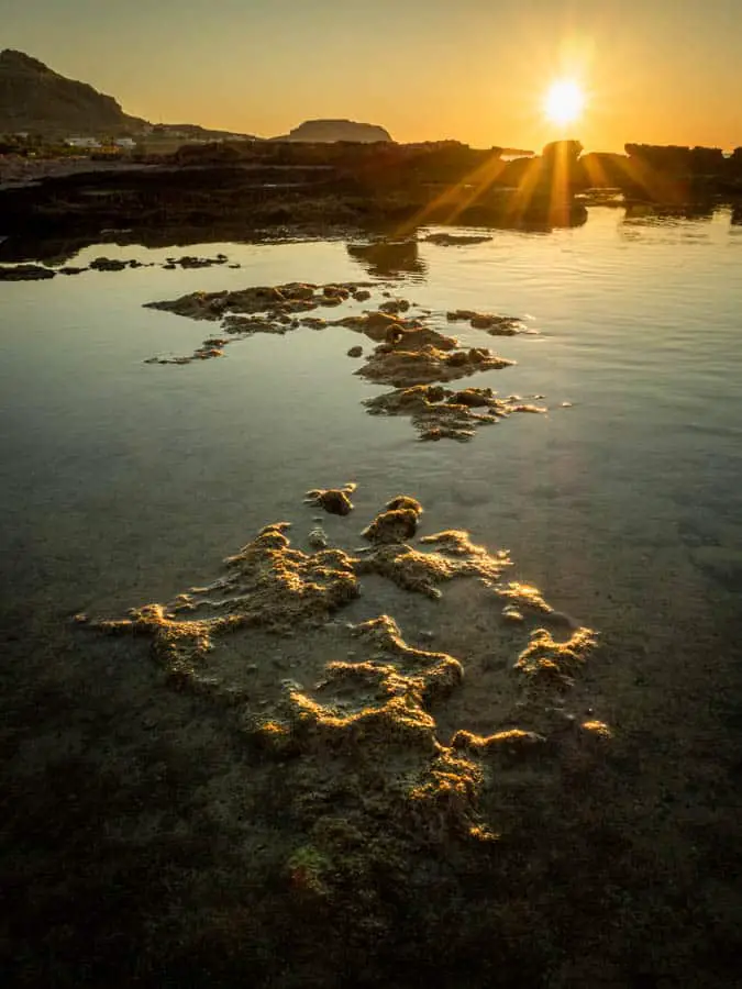 Photo taken at low level of one of the rock pools on the beach at Navarone Bay on the Greek Island of Rhodes with a big bright burst of sunshine. Photo taken with my Olympus OM-D EM5 Mk 2 and 12-40mm F2.8 Pro lens