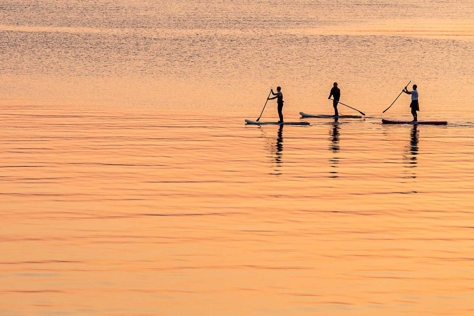  Paddleboarders moving across the water from the Port of Poole to Sandbanks 