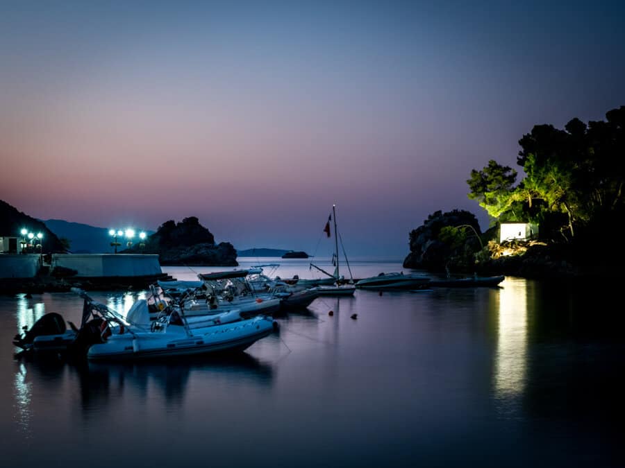 Sunrise view of the boats of Parga and a white building